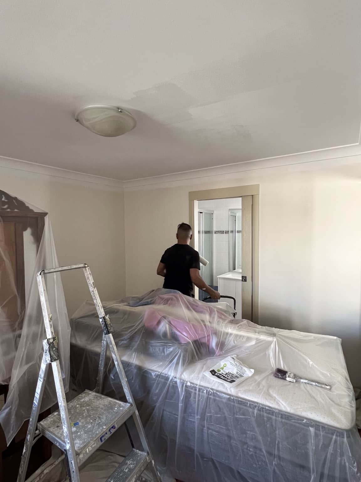 Bedroom preparation with furniture protected before interior painting in Merrylands