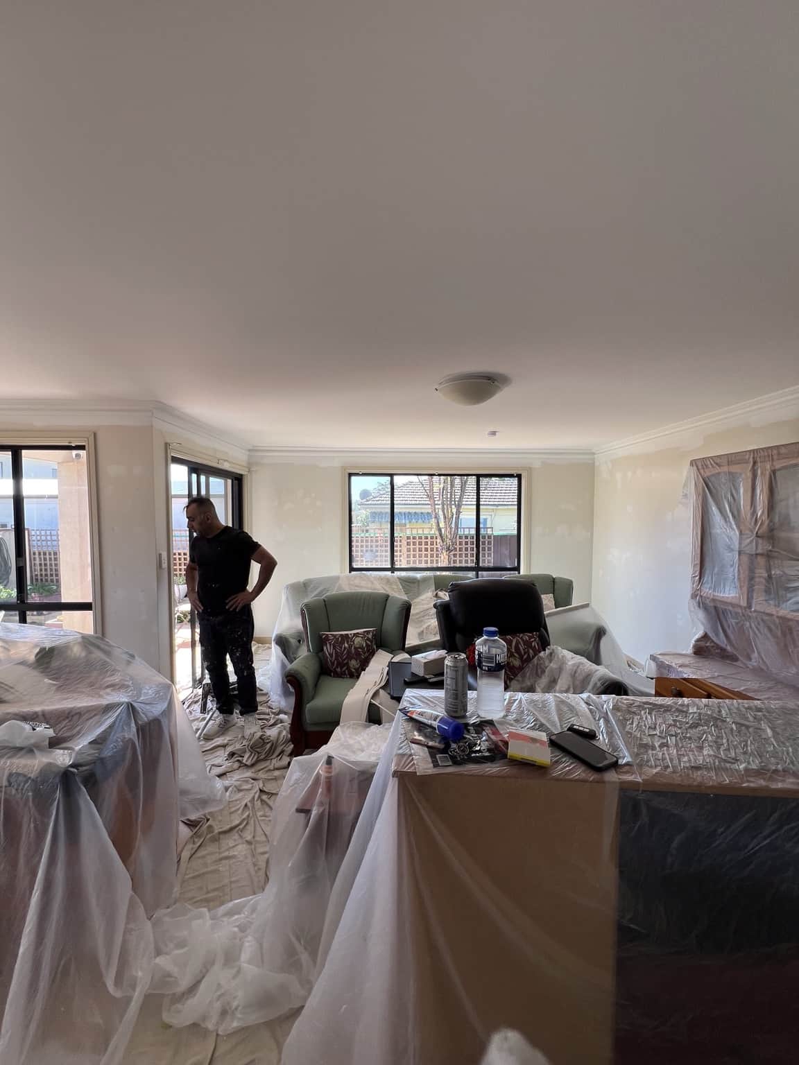 Living room protected and prepared before interior house painting in Merrylands