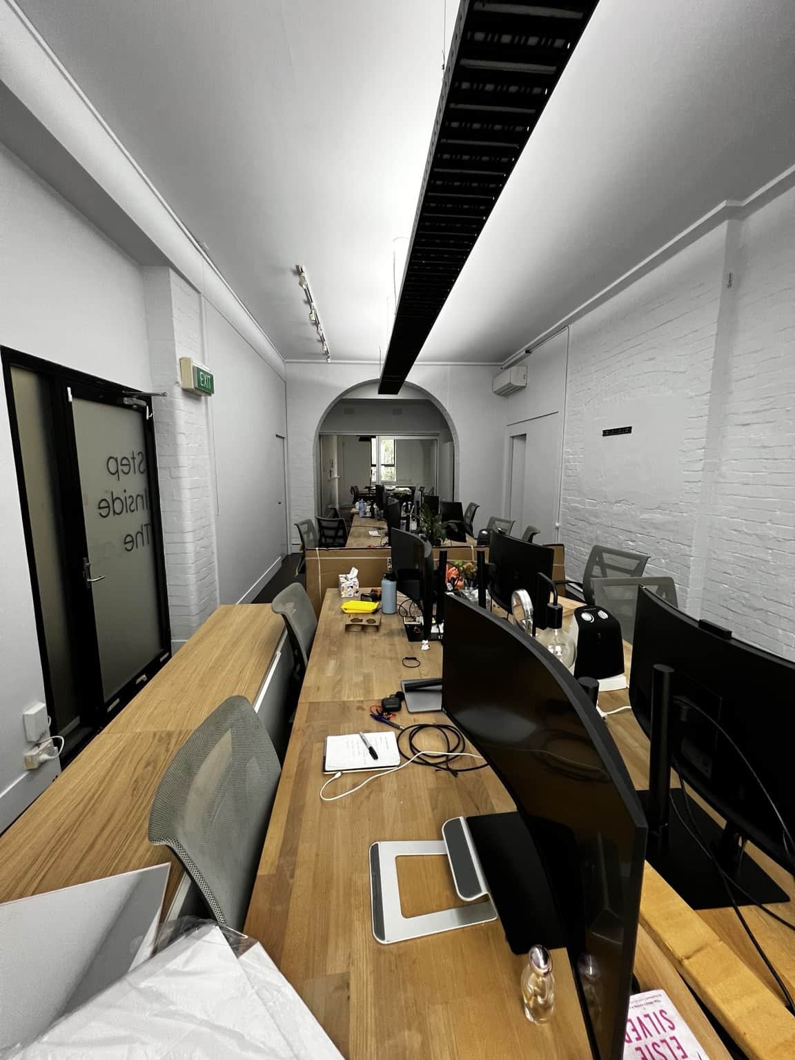 Completed commercial office painting in Chippendale with white brick walls and timber workstations