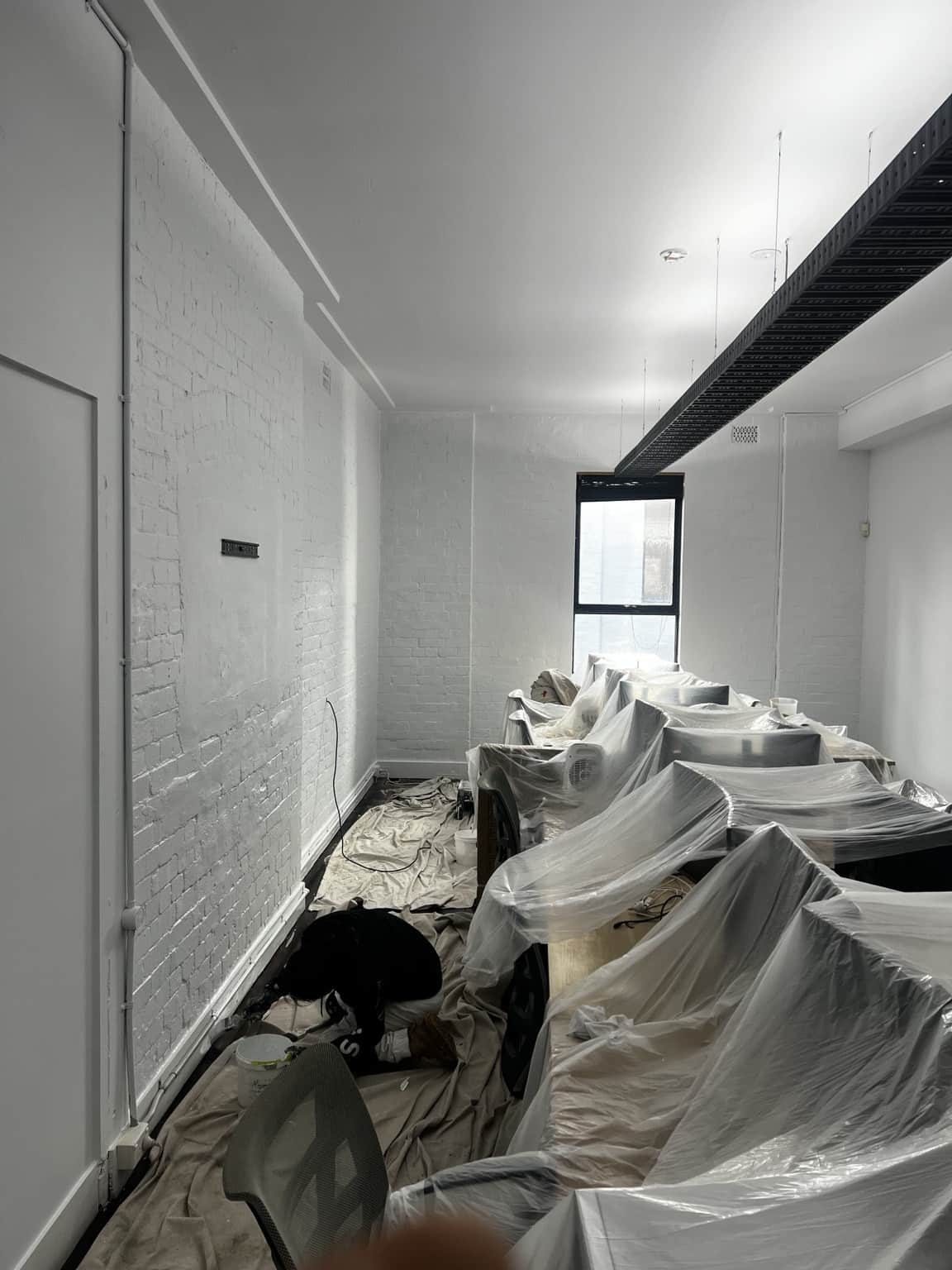 Completed meeting room painting in Chippendale with white walls and dark timber flooring