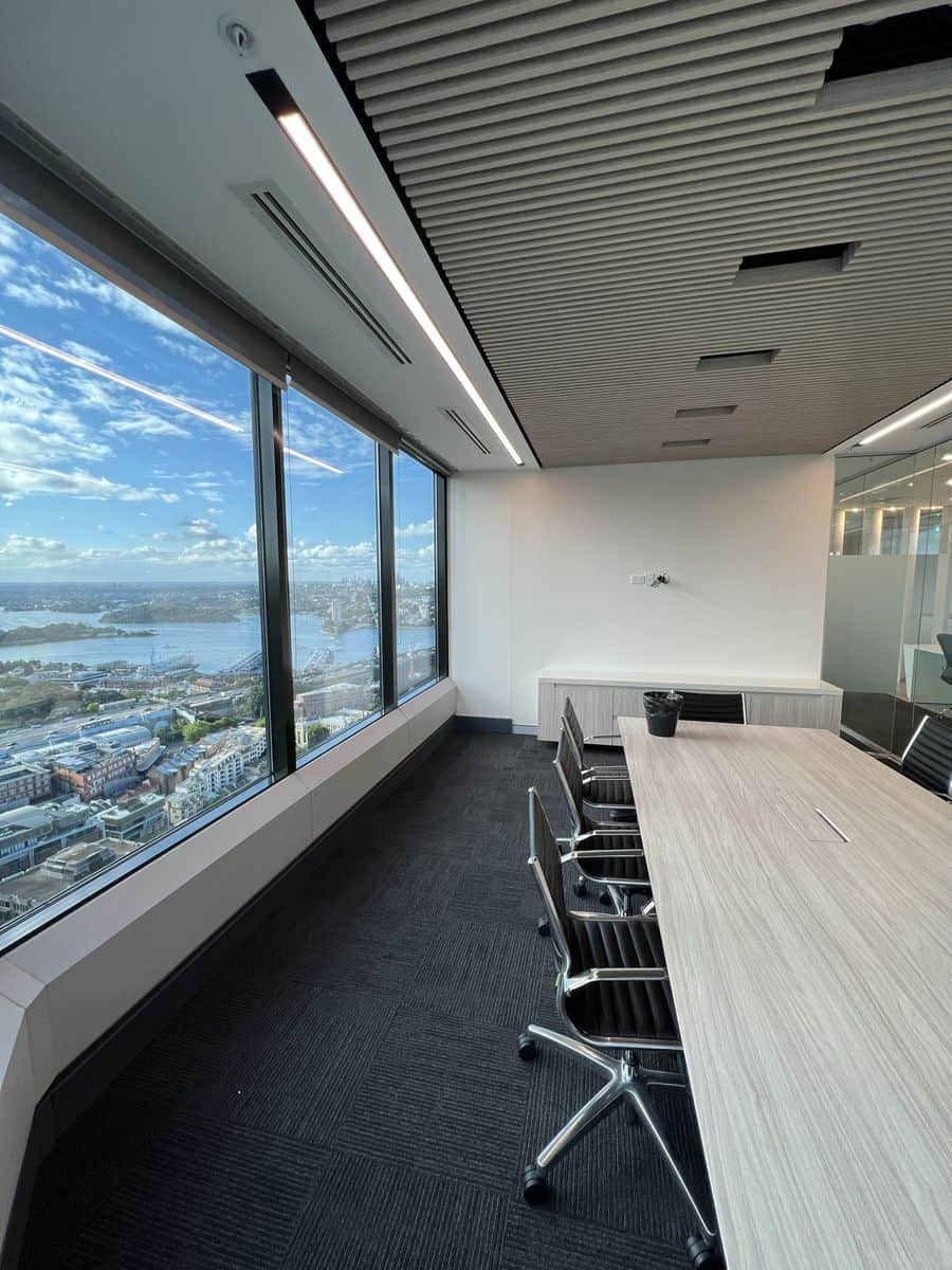 Freshly painted private office in Sydney CBD with crisp white walls, timber shelving and harbour views
