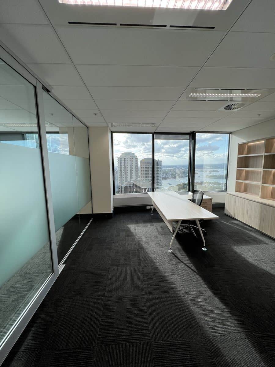 Completed commercial office painting in Sydney CBD with white walls, glass partitions and panoramic city views