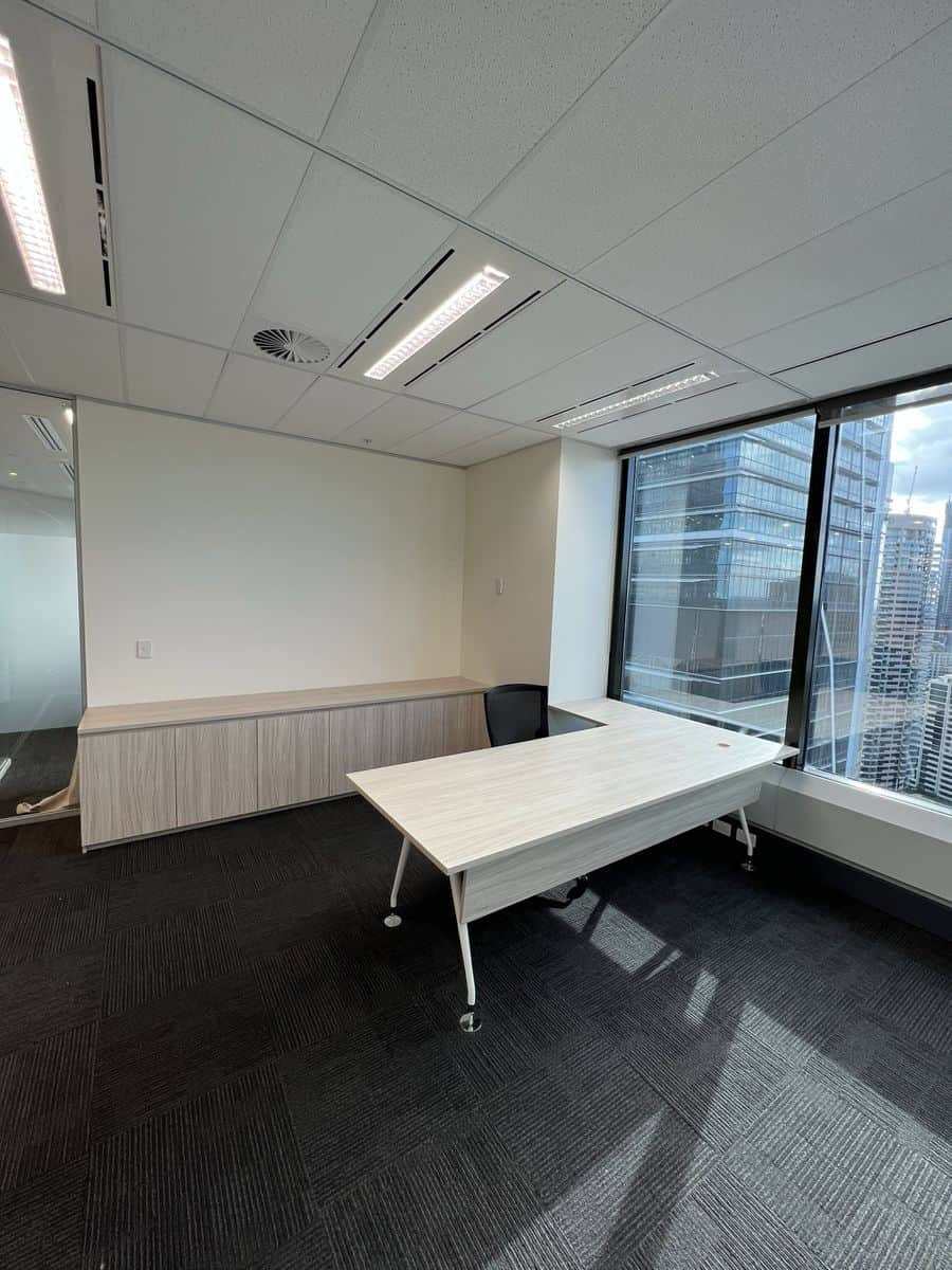 Freshly painted office corridor in Sydney CBD with white columns and modern timber cabinetry