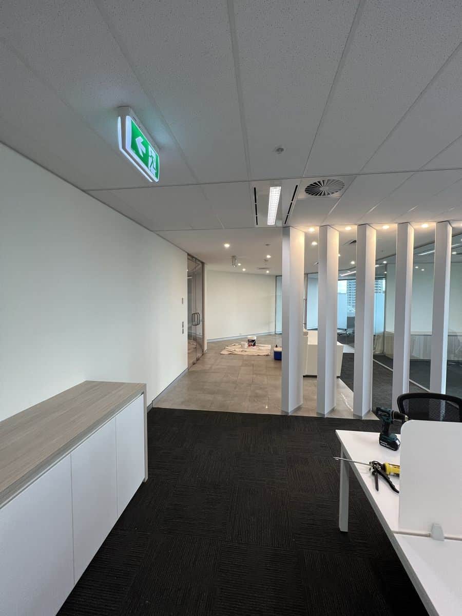 Finished office reception area in Sydney CBD with freshly painted walls and glass-partitioned meeting spaces