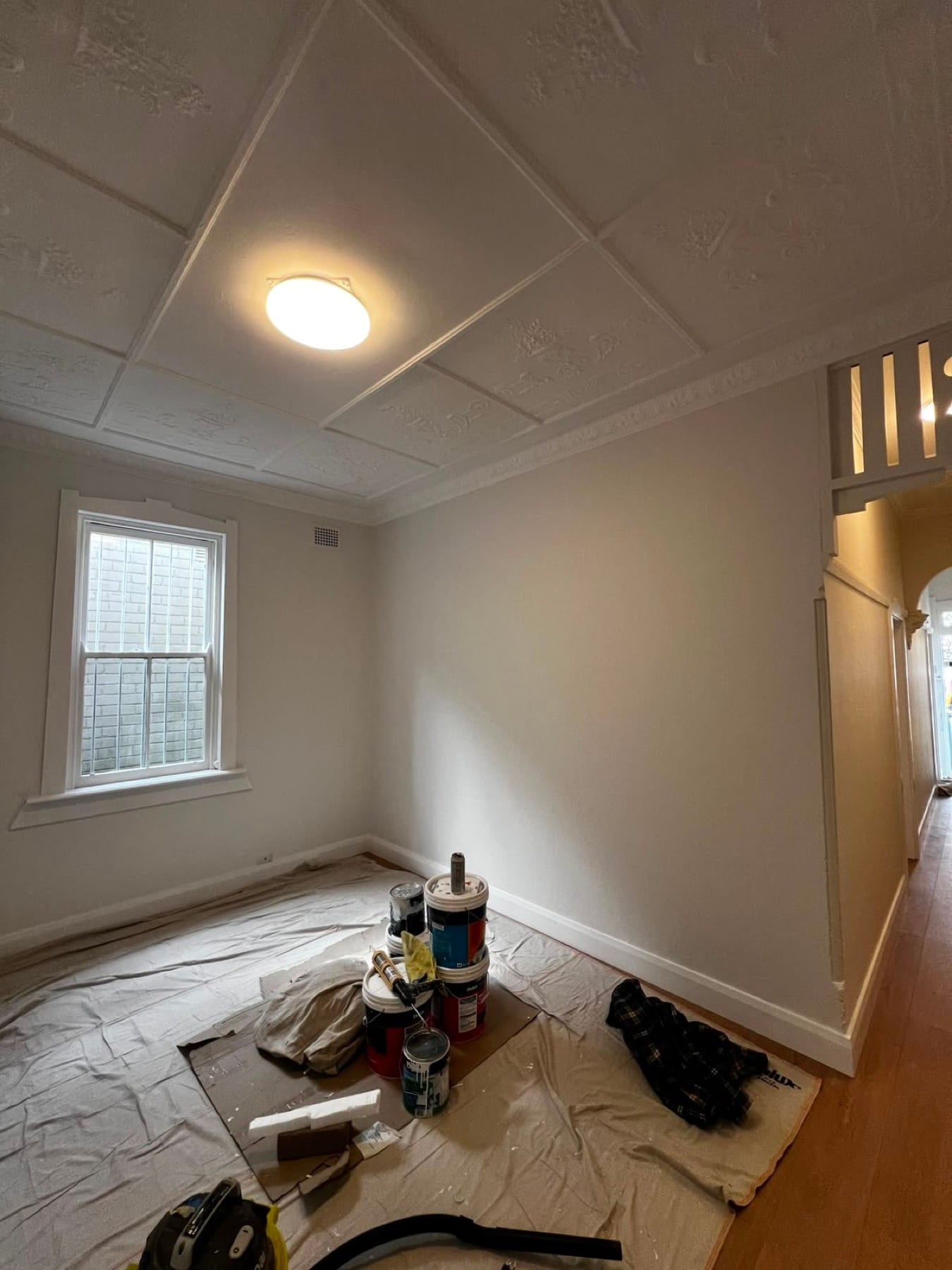Restored pressed-tin ceiling repainted to bring back the period detail, after