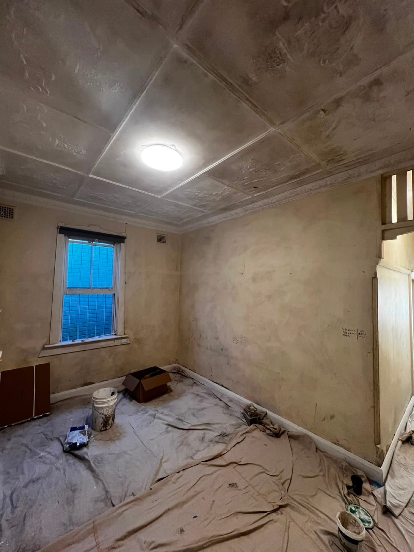 Restored pressed-tin ceiling repainted to bring back the period detail, before