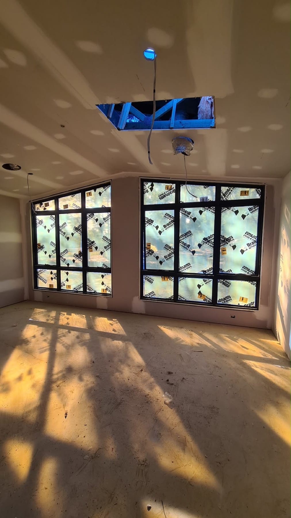 Freshly painted new-build sunroom with full-height windows, before